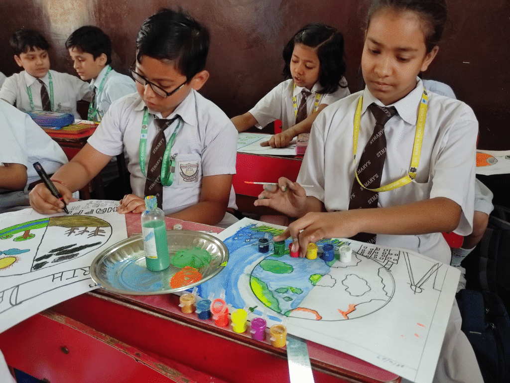 Group of schoolchildren drawing colorful World Environment Day posters