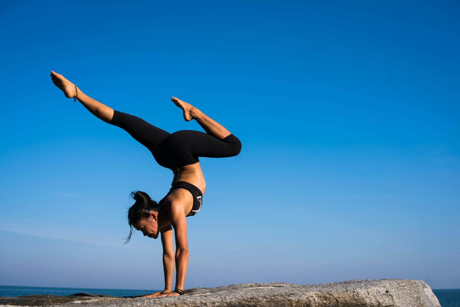 Mulher praticando yoga ao ar livre, representando as tendências de bem-estar de 2025