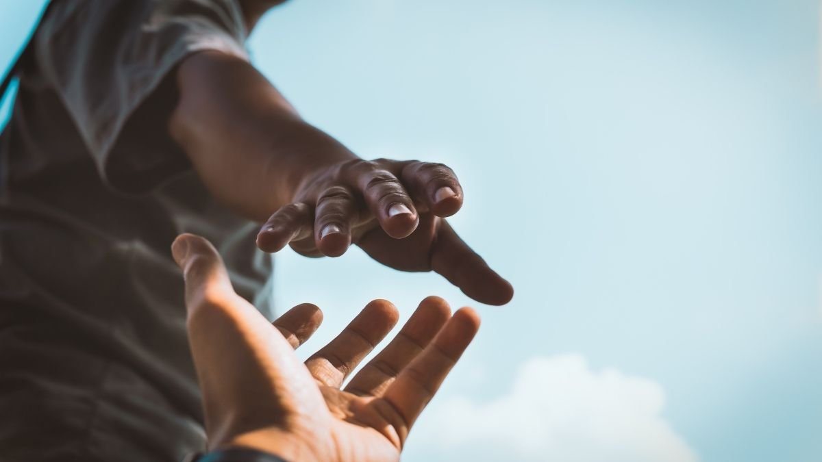 Duas mãos se ajudando, simbolizando como o altruísmo e a ajuda mútua são fundamentais para o sucesso nos negócios.