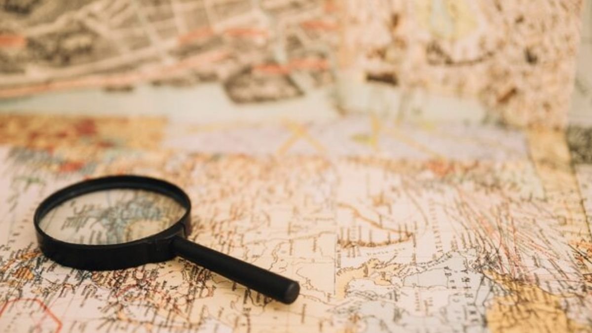 Lupa focando em um ponto específico de um mapa, simbolizando como encontrar um nicho de mercado único.