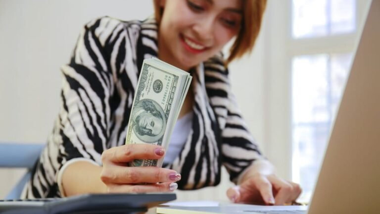 Pessoa trabalhando em um notebook com um globo ao fundo, ilustrando como ganhar em dólar morando no Brasil.