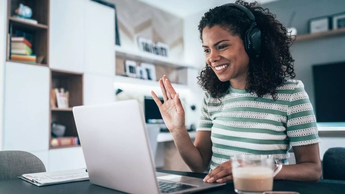 Mulher sorrindo fazendo trabalho remoto.