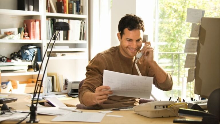 Empreendedor sorrindo em seu escritório, satisfeito por ter encontrado suas verdadeiras motivações para o trabalho