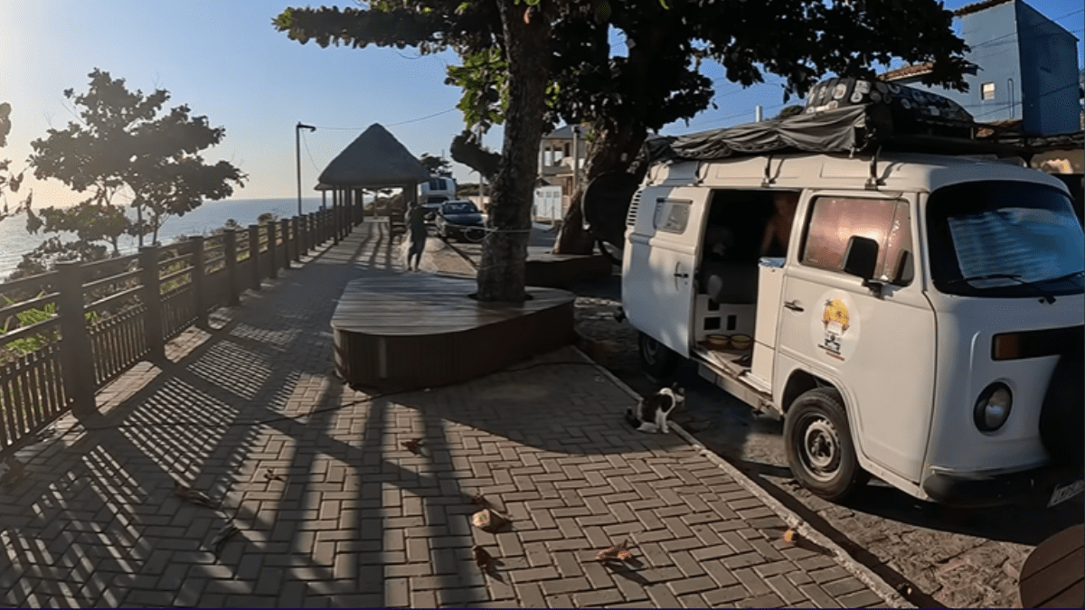 Kombi home estacionada em frente a um lugar tranquilo no Brasil, simbolizando a liberdade e o estilo de vida da vida nômade.